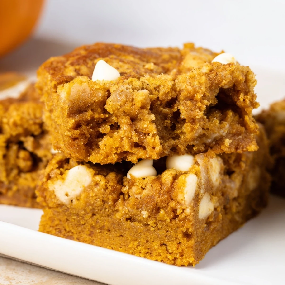 Moist pumpkin muffin blondie bars topped with creamy white chocolate chips.  