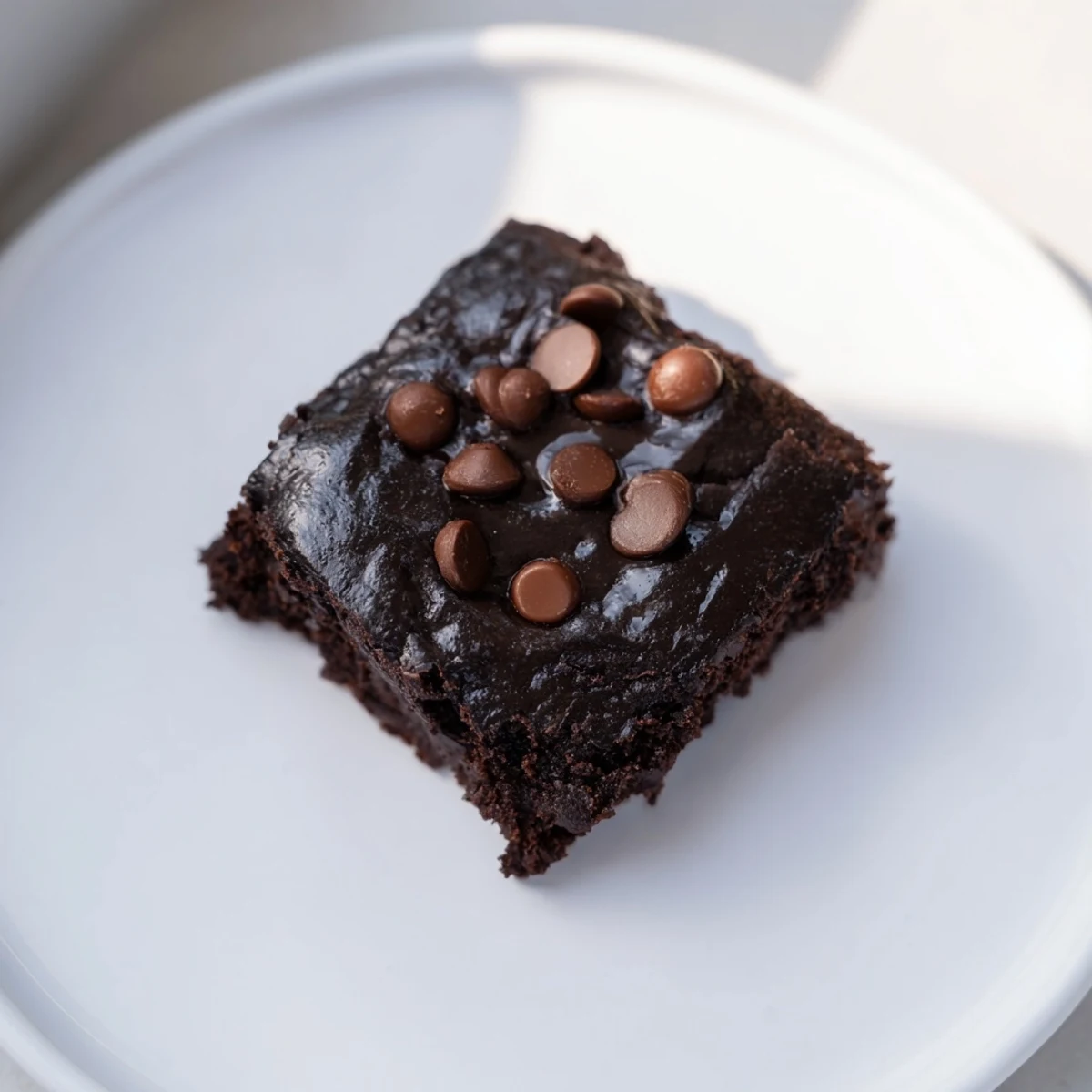 A close-up of deeply chocolate-kissed Black Bean Brownies, showcasing a moist, decadent texture.