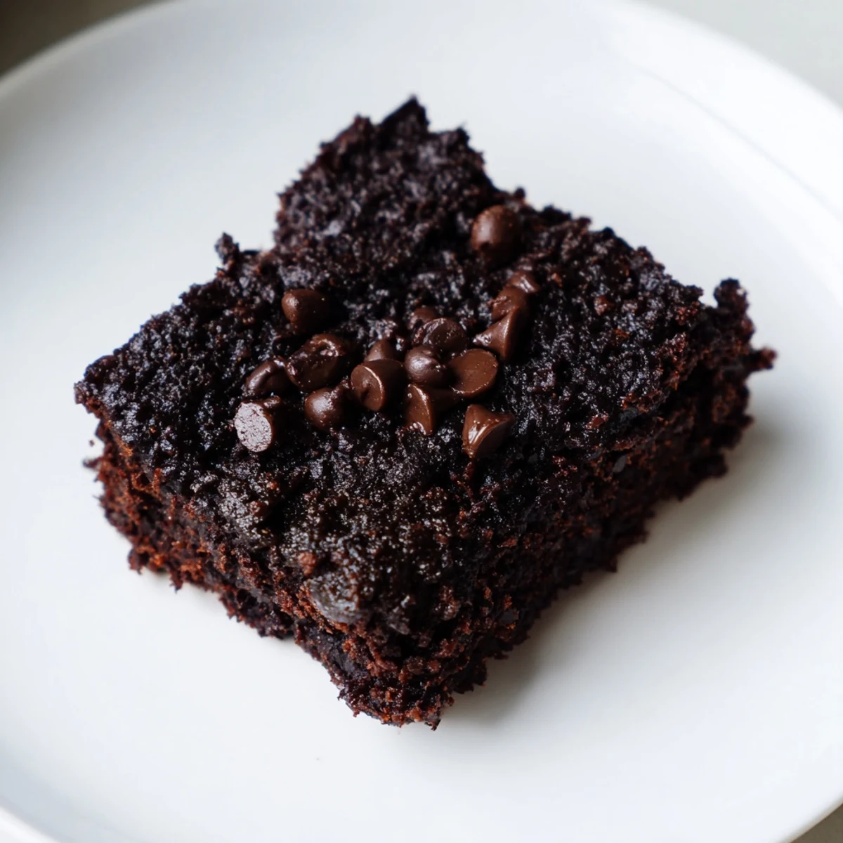 Fudgy Black Bean Brownies, warm from the oven, with a scattering of glistening chocolate chips on top.
