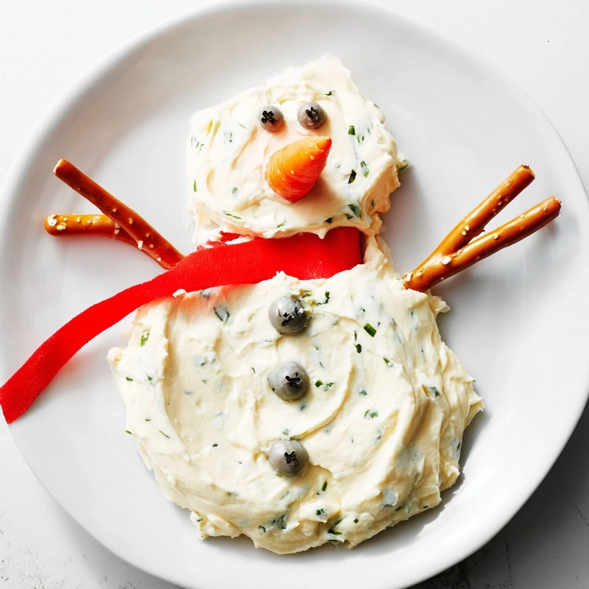 Creamy Melted Snowman Dip, a festive appetizer; a cheesy snowman with carrot nose and pretzel arms.