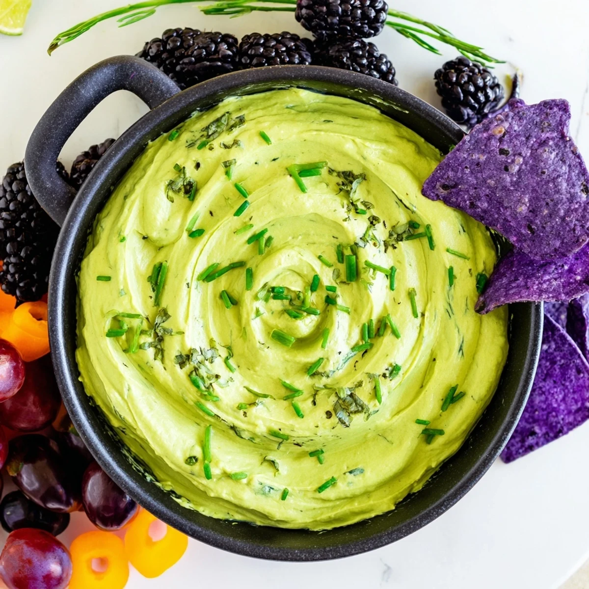 Vibrant, creamy green Witch's Brew Cauldron dip with dark ingredients arranged like a bubbling potion.