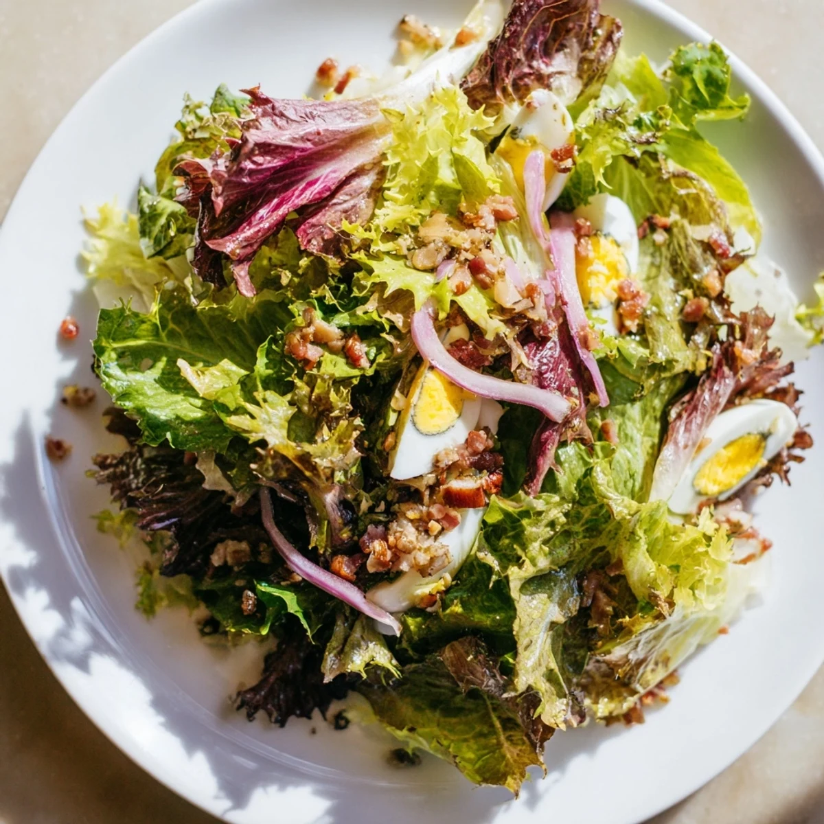 Fresh, vibrant bitter greens salad with warm bacon dressing, ready to enjoy.