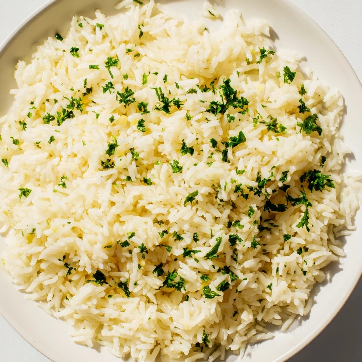 A close-up of fragrant garlic butter rice, featuring tender grains with glistening, savory butter.