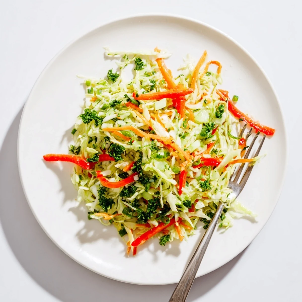 Bright, crunchy Sauerkraut Slaw tossed with fresh green cabbage, grated carrots, and tangy apple cider vinaigrette in a rustic bowl.  