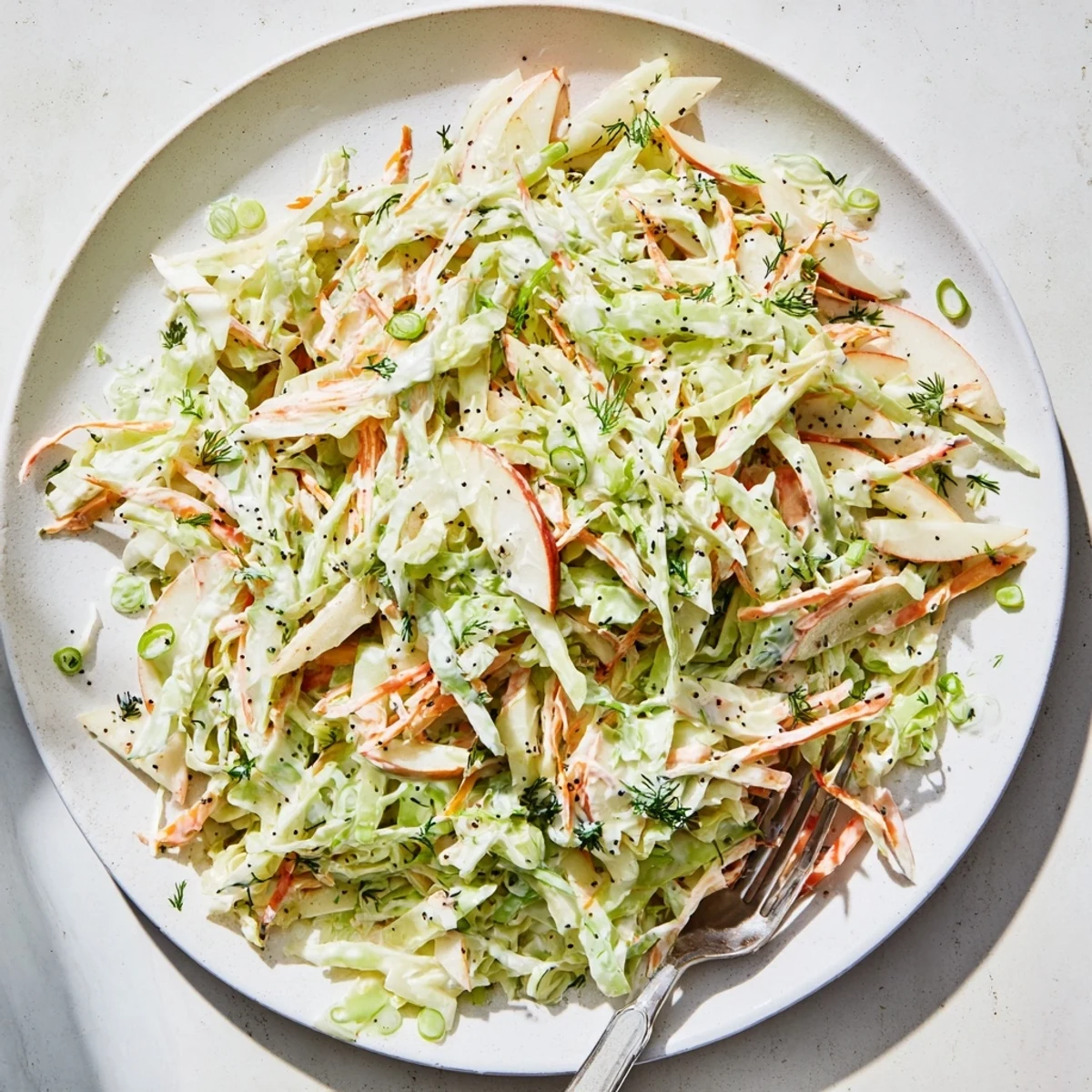 This refreshing Green Cabbage and Apple Slaw features crunchy carrots and green onions, perfect as a side for summer barbecues.