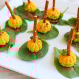 A top-down view of the "Pumpkin Patch" appetizer: neat rows of cheese pumpkins with pretzel stems and parsley.