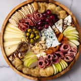 An Elegant Gilded Edge appetizer spread, showcasing an array of fresh fruits and artisanal charcuterie.