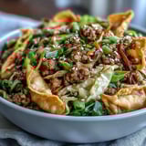 Top-down view of Ranch Turkey & Veggie Egg Roll Bowls with crispy wonton strips and sesame seeds.