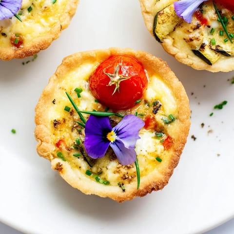 Golden-baked Couronne Florale Mini Quiches, arranged like a wreath, bursting with colorful spring vegetables.
