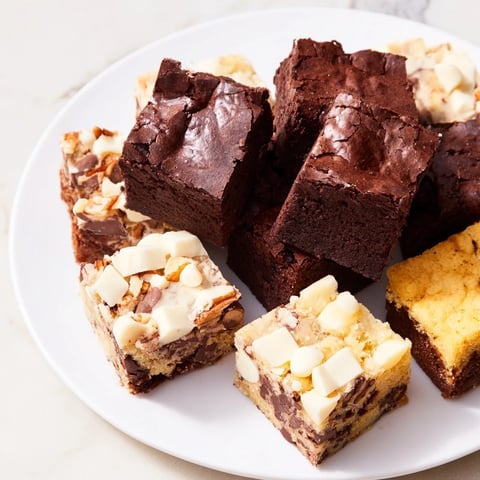 A delicious dessert platter with assorted brownie and blondie squares, ready to enjoy.
