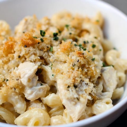 Creamy &quot;Mac and Cheese Chicken Alfredo Bake&quot; served warm, garnished with fresh parsley.
