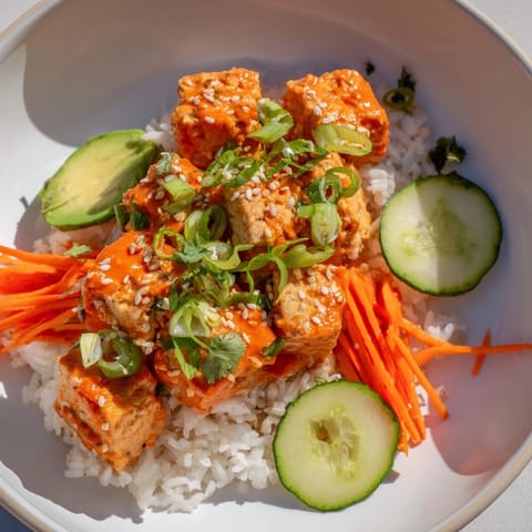 Vibrant image of chili-mayo baked tofu bowls: crispy tofu over fluffy rice, garnished with fresh toppings.