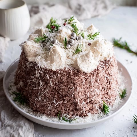 A close-up of Table d'Hiver Sapin et Flocons dessert, a snowy pine tree delight made with white chocolate mousse.