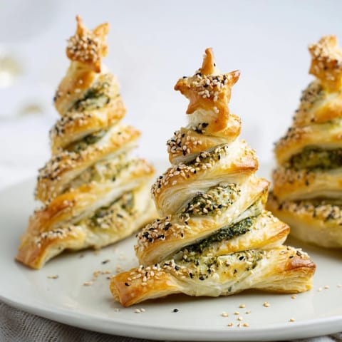 Golden-brown puff pastry Christmas tree appetizer, baked to flaky perfection with sesame seeds.