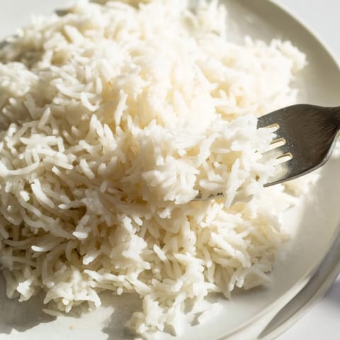 Aromatic, creamy Coconut Jasmine Rice, perfect vegan side dish, simmered to fluffy perfection in a saucepan.