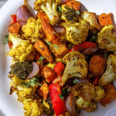A vibrant bowl of Anti-Inflammatory Turmeric Roasted Vegetables, seasoned with spices and garnished with fresh cilantro.  
