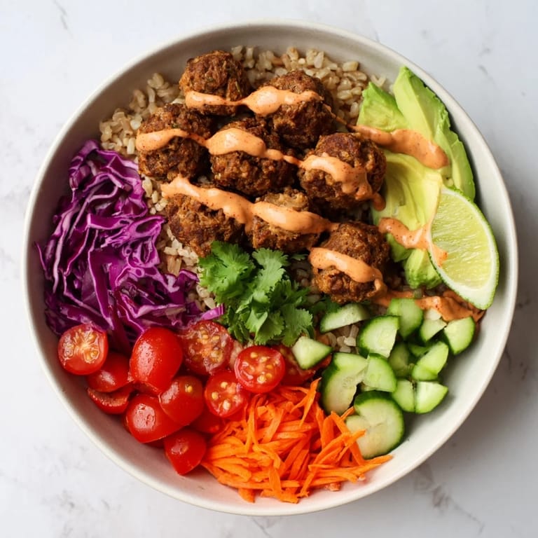 Healthy plant-based meat bowl drizzled with spicy mayo, served with fresh cilantro.