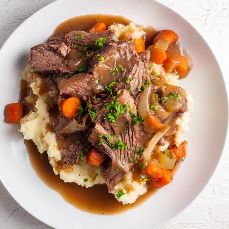 Hearty American dinner: Delicious Slow Cooker Pot Roast with carrots and celery, served with mashed potatoes.