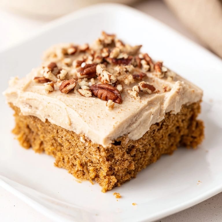 Close-up shot shows frosted Pumpkin Bars with inviting, soft brown sugar swirls.