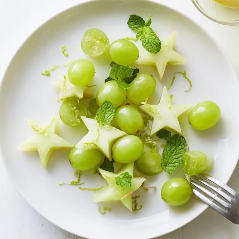 Freshly sliced starfruit and halved grapes, a colorful Brunch Fruit dish, ready to eat alongside waffles.