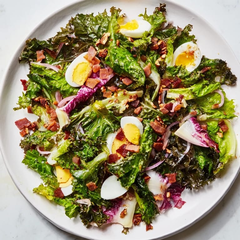 Deliciously wilted bitter greens salad with warm bacon dressing, ready for a warm meal.