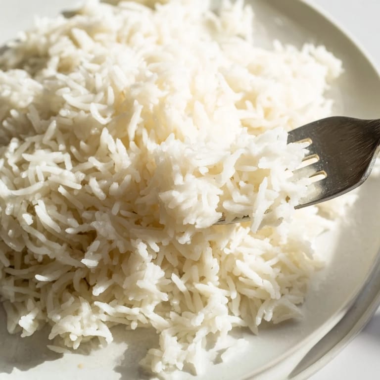 Aromatic, creamy Coconut Jasmine Rice, perfect vegan side dish, simmered to fluffy perfection in a saucepan.